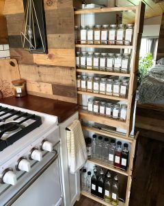 Beautiful space rack kitchen storage organization in a skoolie conversion